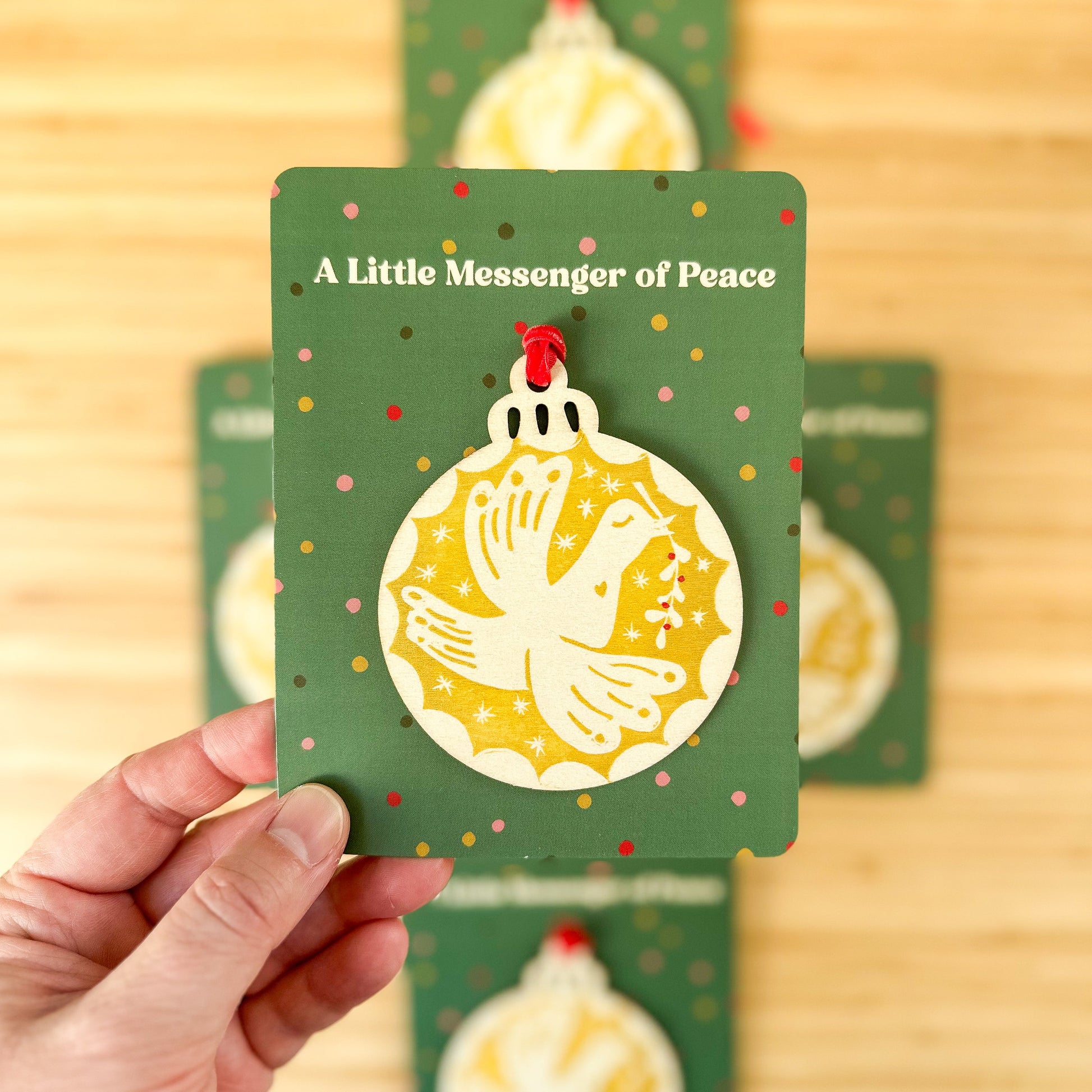 Hand holding a green card with a yellow illustration and text on a wooden surface